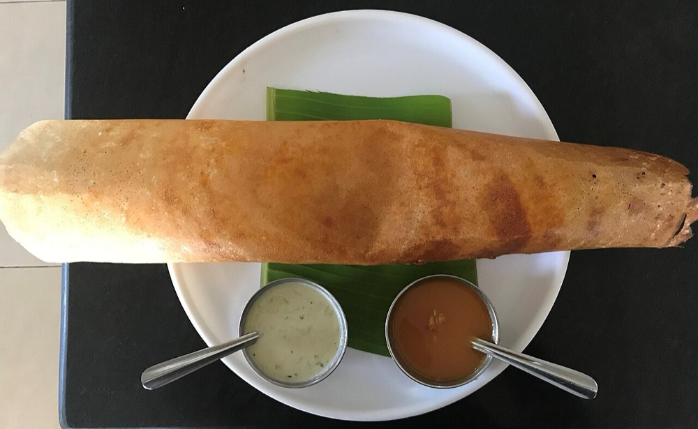 A crispy masala dosa with coconut chutney and sambar