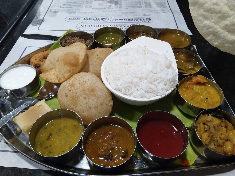 A South Indian thali with rice, sambar, rasam, curries and poori