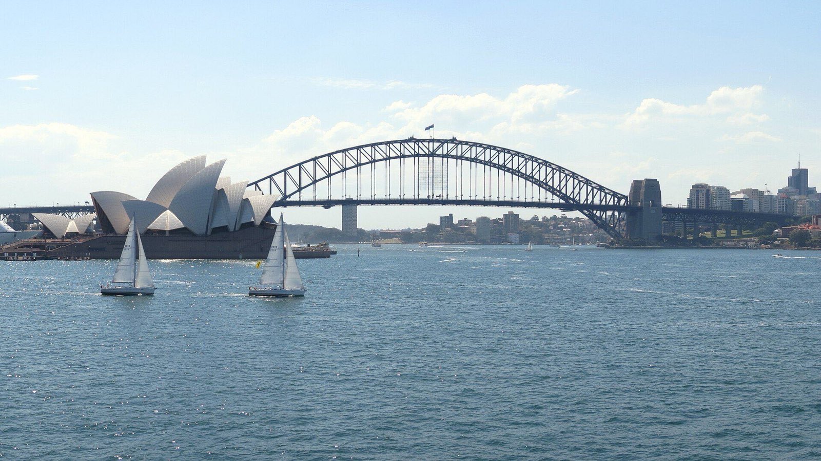 The Sydney Opera House and Harbour Bridge, with sailboats on the harbour